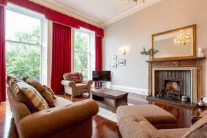 a living room with a couch and a fireplace at ALTIDO Spacious 2BR Apt in New Town, Prime Location in Edinburgh