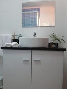 a white bathroom with a sink and a mirror at ParadisMare in Machico