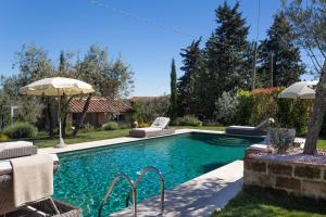 a swimming pool with two chairs and an umbrella at Villa Ligheia in Gambassi Terme