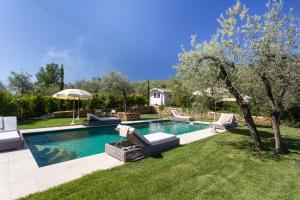 a swimming pool with chairs and an umbrella in a yard at Villa Ligheia in Gambassi Terme +60 photos