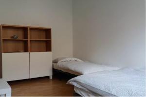 グダニスクにあるPrivate apartment near the city centreのベッドルーム1室(ベッド2台、白いキャビネット付)