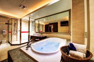 a bathroom with a tub and a large mirror at Wsb Motel-Rende in Tainan