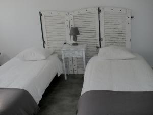 two beds sitting next to each other in a bedroom at La Jumelière Laval Nord in Changé