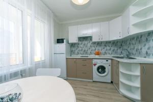 eine weiße Küche mit Waschmaschine in der Unterkunft Софии Русовой 7 in Kiew