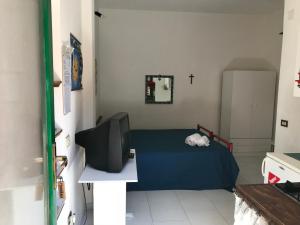 Habitación pequeña con cama y TV. en Case del Tramonto, en Ustica