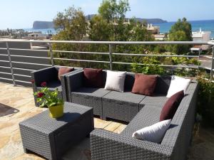 un patio con 2 sofás y una mesa con una planta en Rubini Homes, en Agia Marina de Nea Kydonia