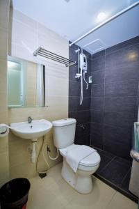 a bathroom with a white toilet and a sink at Eden Boutique Hotel in Tawau