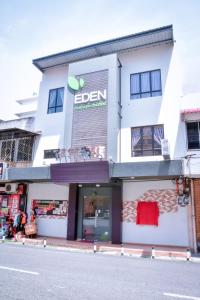 a white building with a sign on the side of it at Eden Boutique Hotel in Tawau