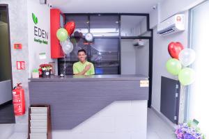 a man standing behind a counter in a kitchen with balloons at Eden Boutique Hotel in Tawau