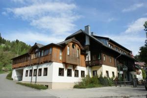 a large house with a wooden roof at Landgasthof zum Scheiber in Sirnitz