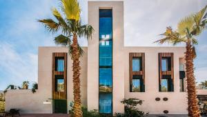 a building with palm trees in front of it at H Boutique Peña Parda in La Herradura