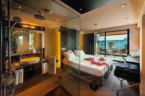 a hotel room with a bed and a sink and a bathroom at H Boutique Peña Parda in La Herradura