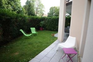 two green chairs sitting on the grass in a yard at Appartement Le Louvre in Dijon