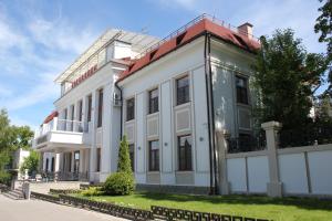 a white building with a red roof at Бутик отель Боровница in Solotcha