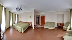 a bedroom with a bed and a couch and chairs at Aximaris furnished rooms in Saint Petersburg