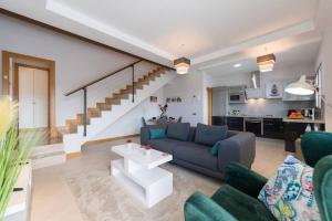 sala de estar con sofá azul y escalera en Vista Golf 15, en La Playa de Arguineguín