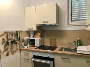 uma cozinha com um lavatório e um micro-ondas em Apartments Zdravko em Trogir