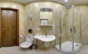 y baño con aseo, lavabo y ducha. en Aximaris furnished rooms, en San Petersburgo