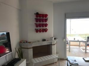 salon z kominkiem z czerwonymi garnkami na ścianie w obiekcie Chalkidiki Olivia Beach w mieście Gerakini