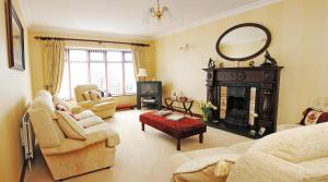 a living room with a fireplace and a mirror at Cottesmore Bed and Breakfast in Bushmills