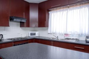 a kitchen with brown cabinets and a sink and a window at Seabrook 210 in Margate