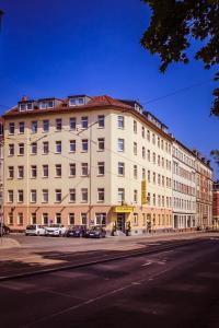 un grand bâtiment blanc sur le côté d'une rue dans l'établissement Hotel Berlin, à Leipzig