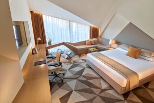 a hotel room with a bed and a living room at Vivanta New Delhi, Dwarka in New Delhi