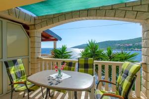 a table and chairs on a balcony with a view of the water at Apartments Ranko in Zavalatica