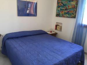 a bedroom with a blue bed in a room at Appartamento a due passi dal mare 8 posti letto in San Vito lo Capo