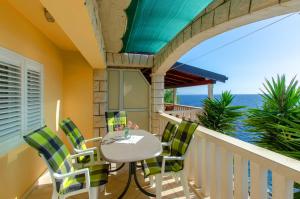 a balcony with a table and chairs and the ocean at Apartments Ranko in Zavalatica