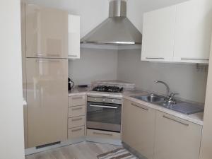 una cucina bianca con piano cottura e lavandino di Skyline, Casa Vacanze a Savona