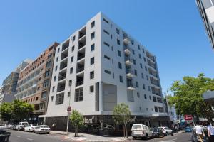 a tall white building on a city street at Flatrock Apartments in Cape Town