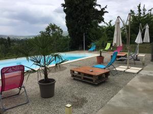 een zwembad met stoelen en een tafel en een tafel sidx sidx bij Les Palettes in Salavas