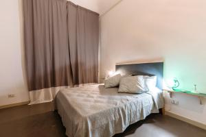 - une chambre avec un lit et une fenêtre avec des rideaux dans l'établissement Case Barbera Via Parlamento, à Palerme