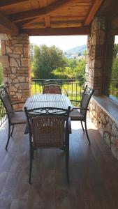 a patio with a table and chairs on a porch at Castello Bellos Villas & Apartments in Keri