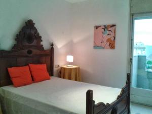 ロザスにあるApartament Roses Costa Bravaのベッドルーム1室(オレンジ色の枕と窓付)
