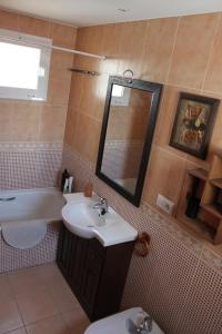La salle de bains est pourvue d'un lavabo, de toilettes et d'un miroir. dans l'établissement Adosado Alcossebre Vacaciones, à Alcossebre