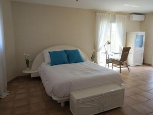 sypialnia z dużym białym łóżkiem i niebieskimi poduszkami w obiekcie Stylish Alfàs del Pi Stay w mieście Albir
