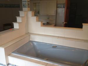 eine Badewanne im Bad mit einer Treppe in der Unterkunft The Farmhouse B&B in Goole