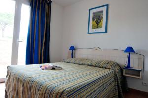 a bedroom with a bed with a bag on it at Résidence Goélia Le Village Azur in Puget-sur-Argens