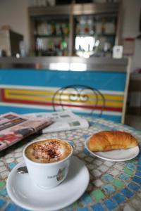 a cup of coffee and a croissant on a table at Hotel Dorico in Ancona