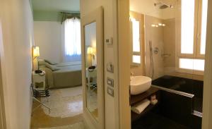 a bathroom with a sink and a bathroom with a bed at Hotel Sant'Antonin in Venice