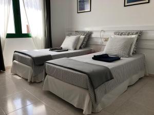 duas camas sentadas uma ao lado da outra num quarto em Apartamentos Flamboyant Adults Only em Puerto del Carmen