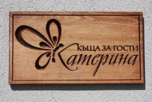 a wooden sign with a butterfly on a wall at KATERINA guest house in Kocherinovo