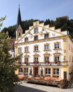 a large white building with a church in the background at Gasthof zur Post in Riedenburg