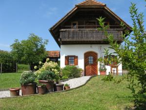 a house with a thatched roof and potted plants at Ferienhaus Troadkasten - Familie Friedrich in Hartberg