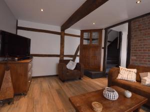 a living room with a couch and a television at Charming cottage near famous Francorchamps in Francorchamps