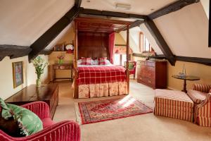 a bedroom with a bed with a red bedspread at Burford House BH in Burford