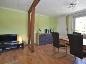 een woonkamer met een houten tafel en stoelen bij Cozy Apartment in Braunlage near Forest in Hohegeiß