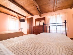 1 dormitorio con 2 camas y techo de madera en Il Becco Felice, en Arpino